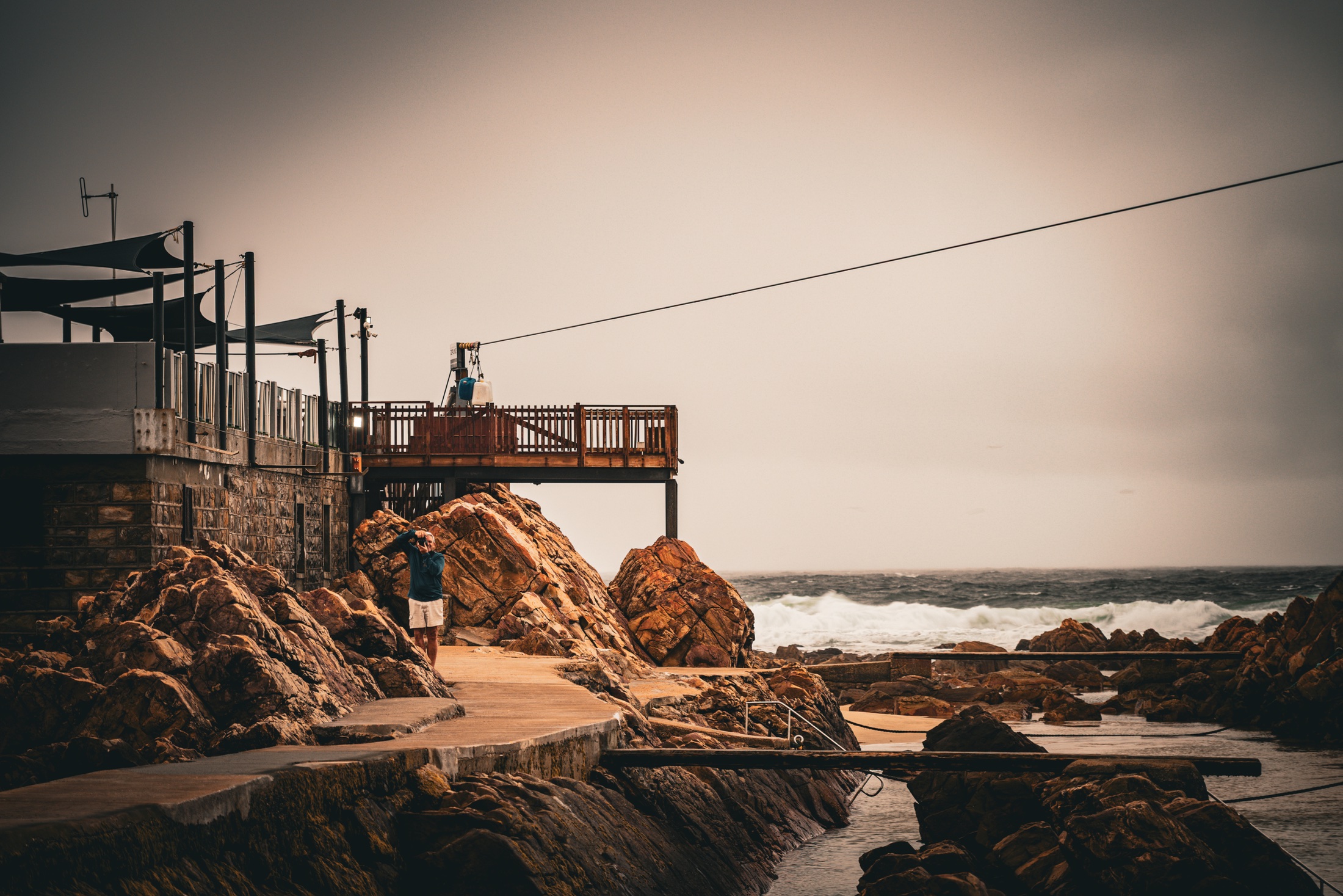 The Mossel Bay zipline platform extending above jagged coastal rocks with the ocean beyond